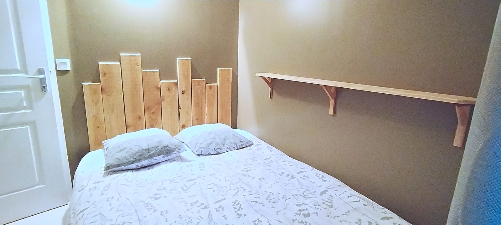 Chambre 4, lit double et tête de lit en bois clair