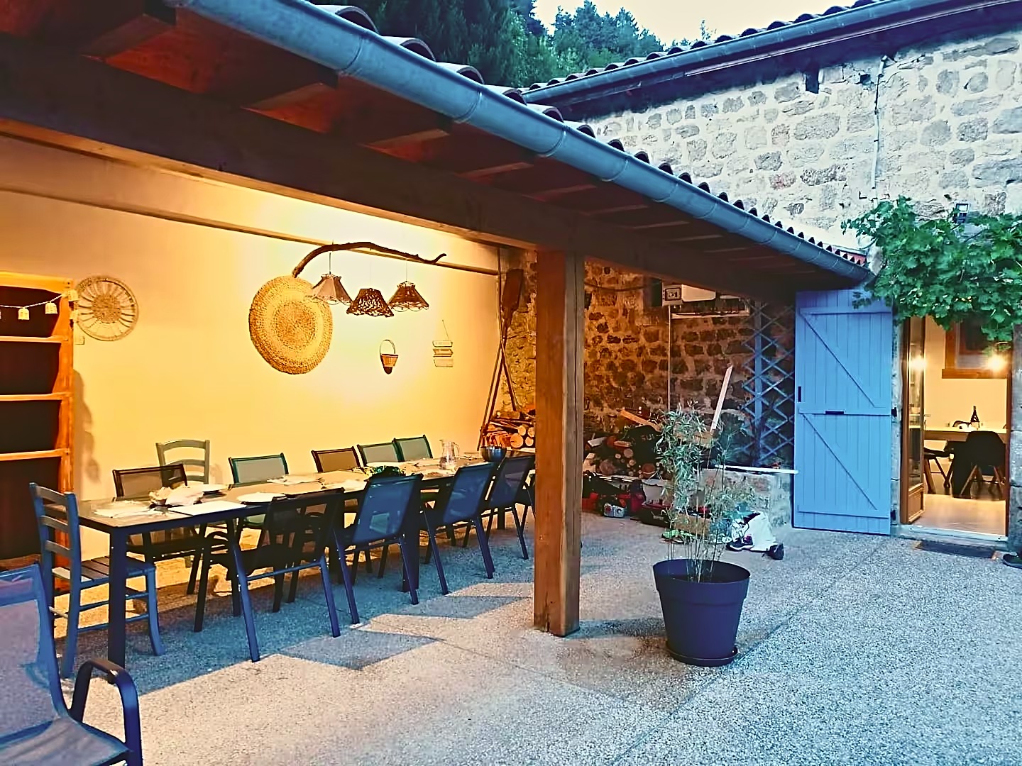 La terrasse couverte le soir, avec sa grande table
